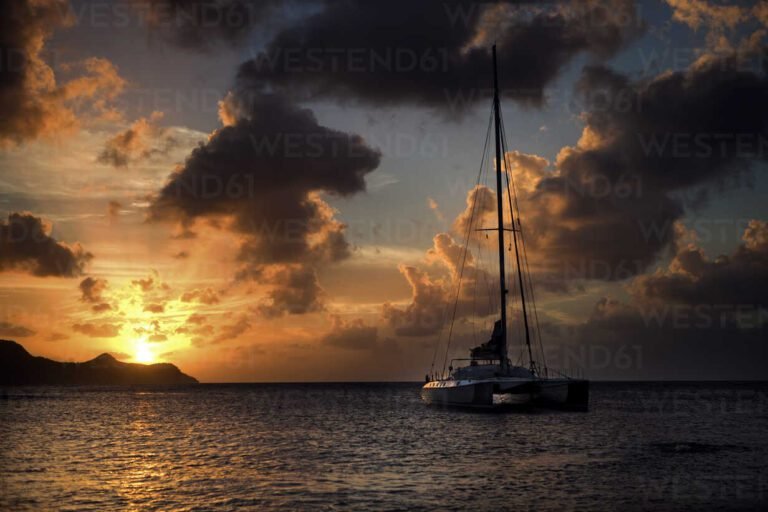 boats sailing under a sunset sky
