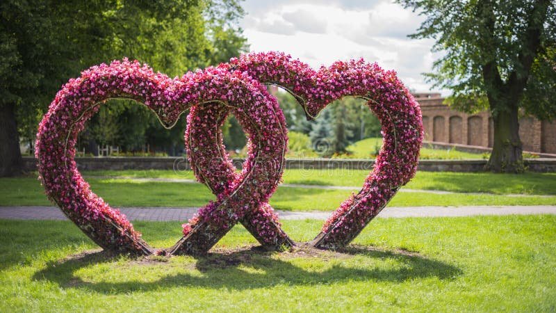Cómo escribir un poema de amor con frases que enamoren 1 corazones entrelazados con flores de fondo