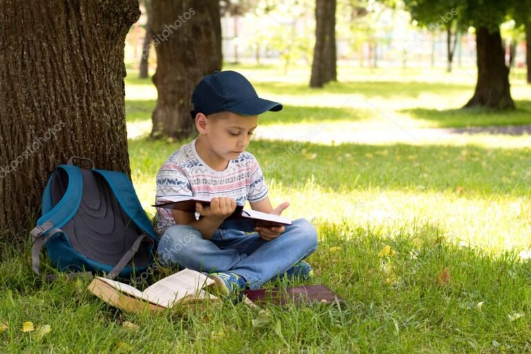 nino leyendo un libro en un parque