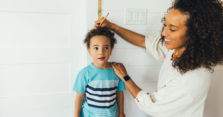 nino midiendo su altura con un metro