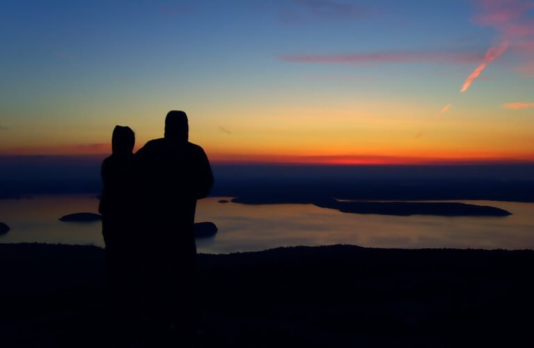 pareja sonriendo bajo un amanecer brillante
