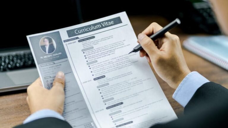 persona escribiendo en un curriculum vitae