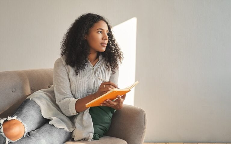 persona reflexionando con un diario