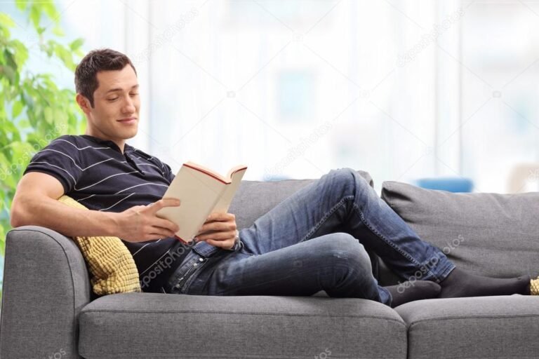 una persona leyendo un libro en un sofa